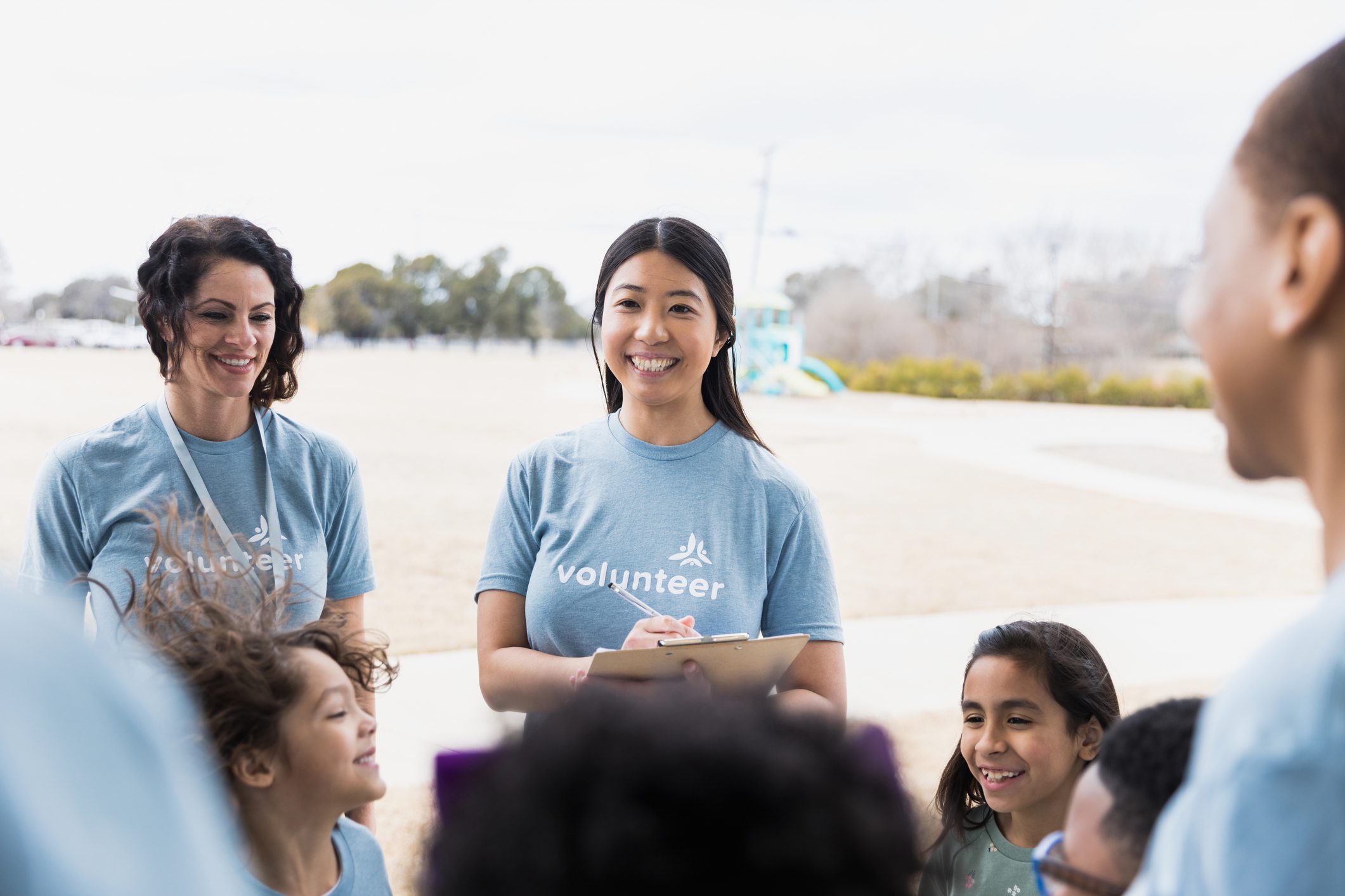Group of volunteers and kids smiling outside